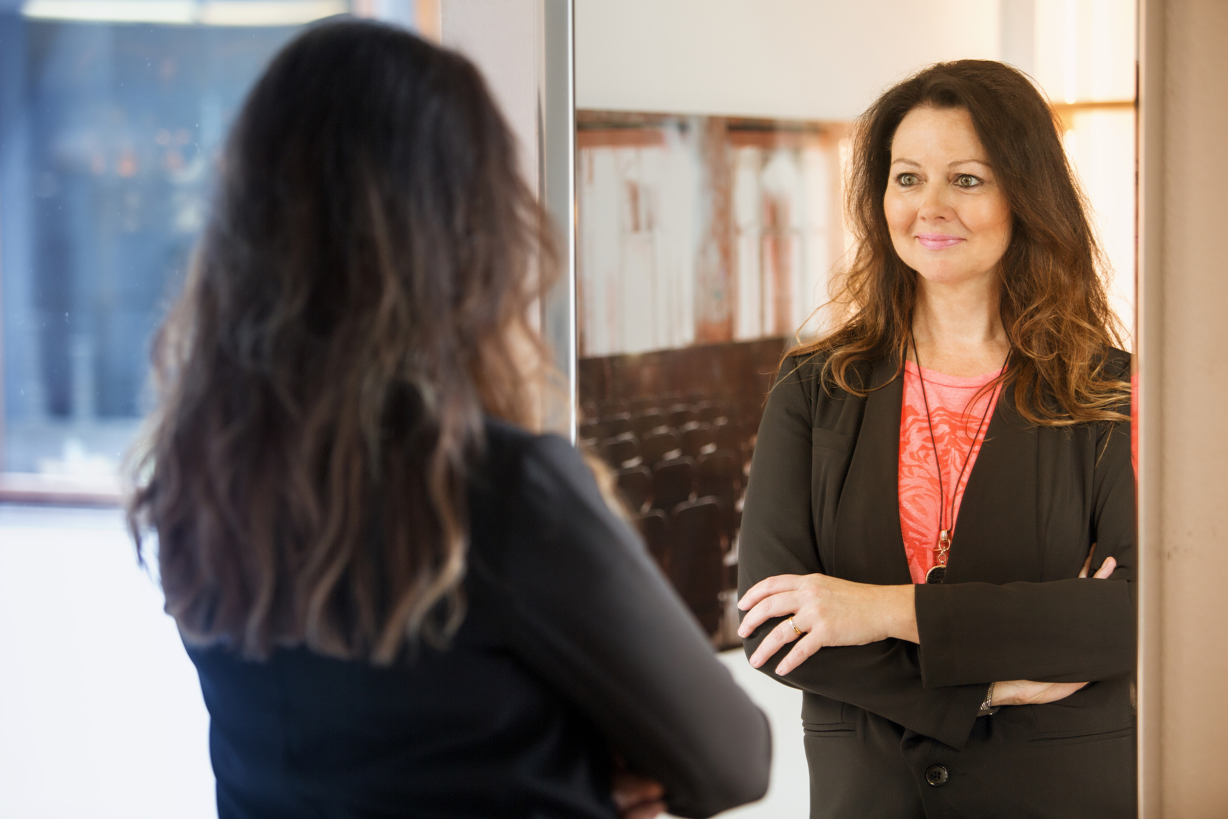 Woman smiling at herself in a mirror